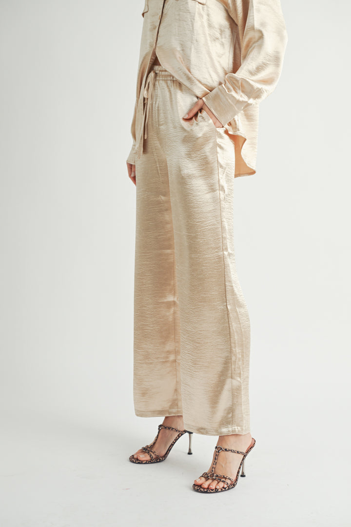 Women Wholesale brand Metallic Pants The elastic waist ensures a customizable and flattering fit, while the wide-leg silhouette adds a touch of modern flair.